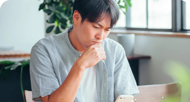 スマホを見て考えるパパ
